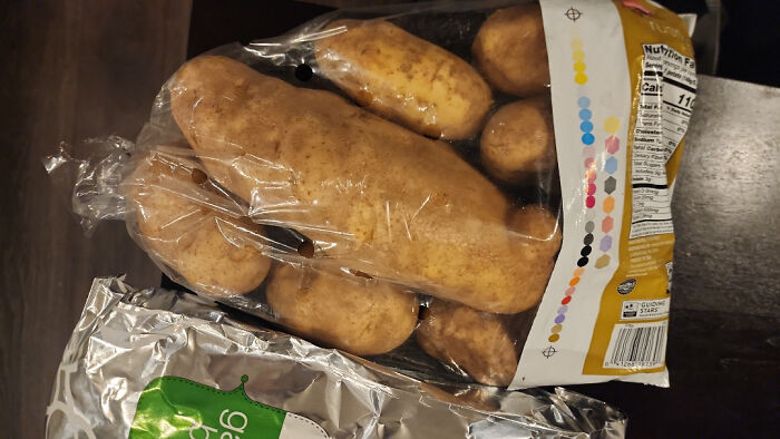 Bag of potatoes on dark surface with plastic packaging