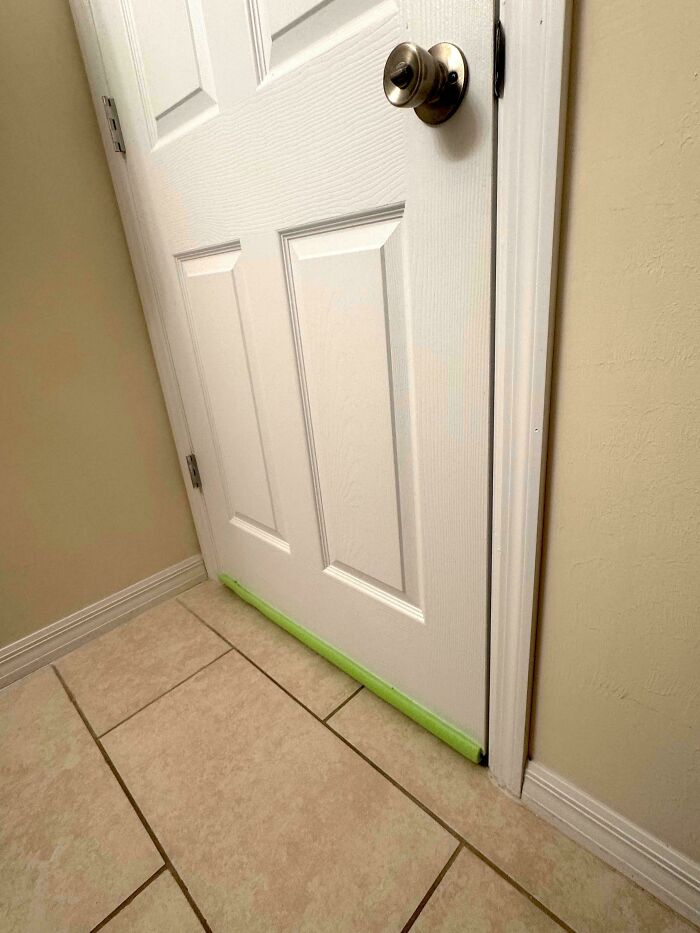 Door draft stopper attached to bottom edge to block air flow