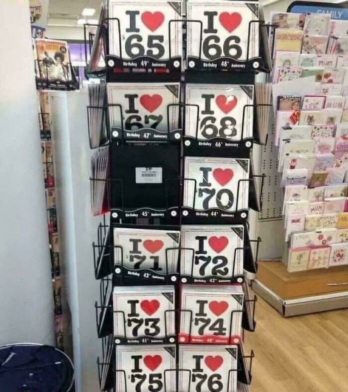 Greeting cards with heart designs and numbers displayed on a rack in a store