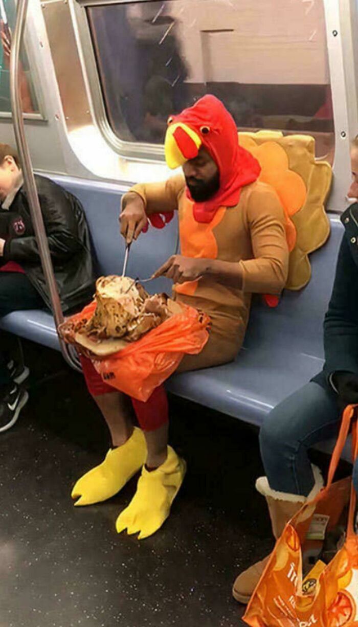 Man dressed in turkey costume eating a whole roasted turkey on subway
