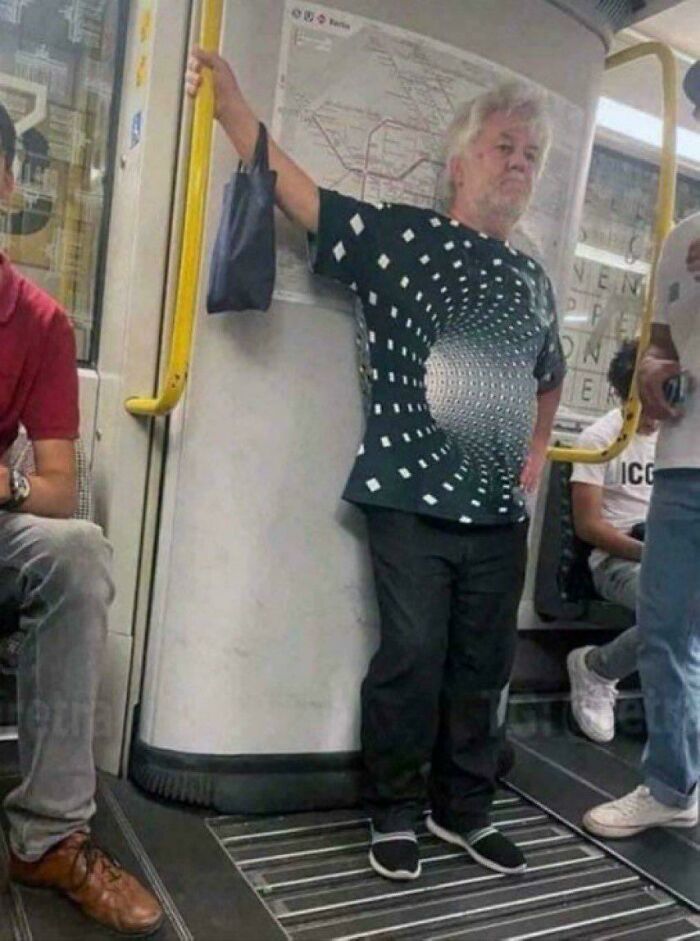 Man wearing optical illusion shirt that looks like a tunnel on subway