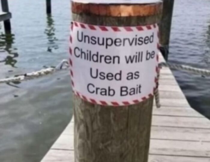 Funny warning sign on dock about unsupervised children used as crab bait