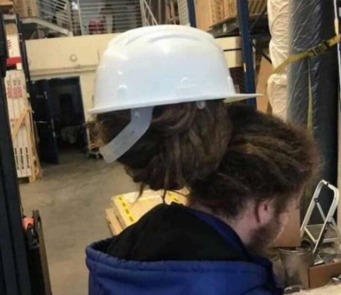 Person wearing a white hard hat that looks like hair in hmmm image