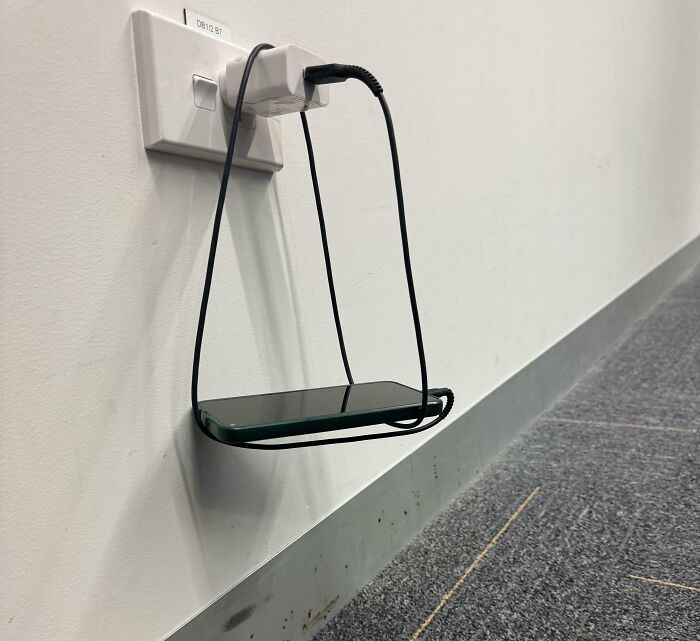 Creative phone charging holder made from a power cord looped to hold phone
