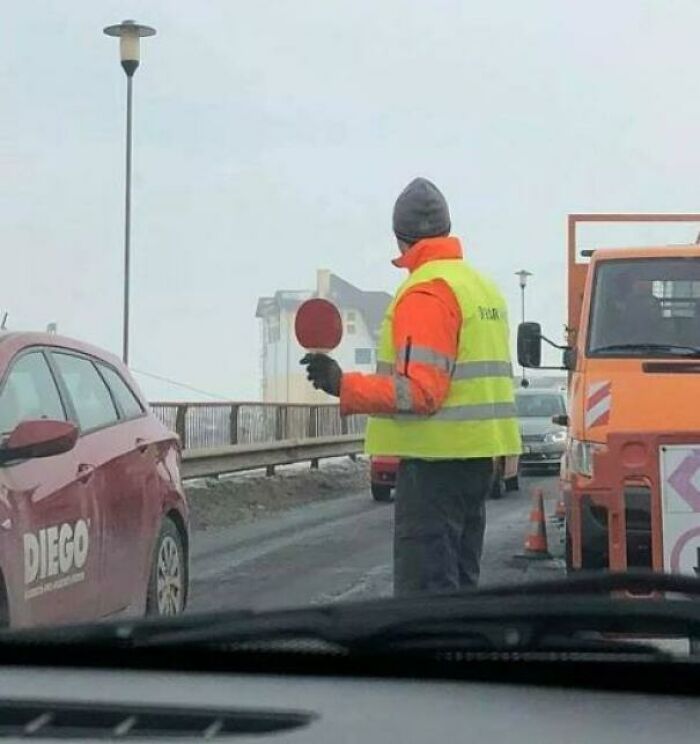 Roadwork worker using handheld stop sign for traffic control