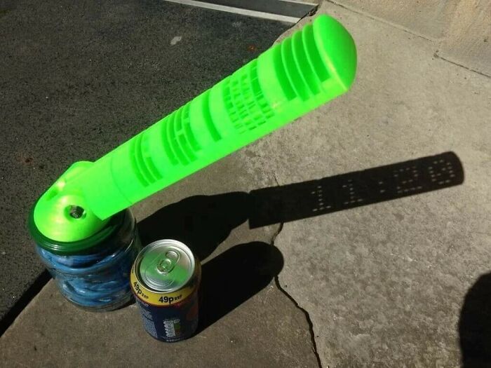Low-tech shadow message with green tool projecting text on pavement
