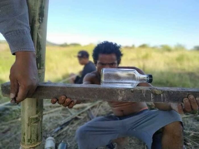 Low-tech solution using a bottle balanced on a plank for a practical purpose outdoors