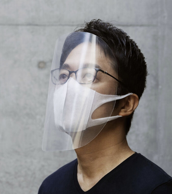 Person wearing a face shield combined with a face mask as low-tech protection