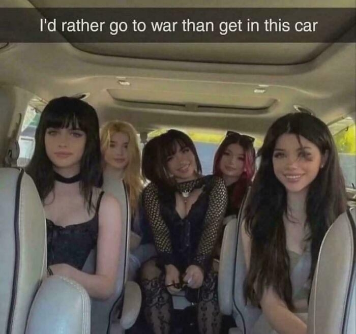 Five girls dressed as The Flintstones characters inside a car with text about going to war over the car