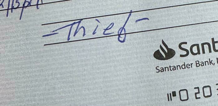 Close-up of a note with the word thief written on a Santander Bank document