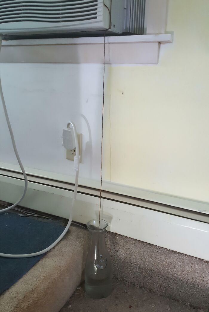Long string hanging from air conditioner to water glass below as low-tech solution