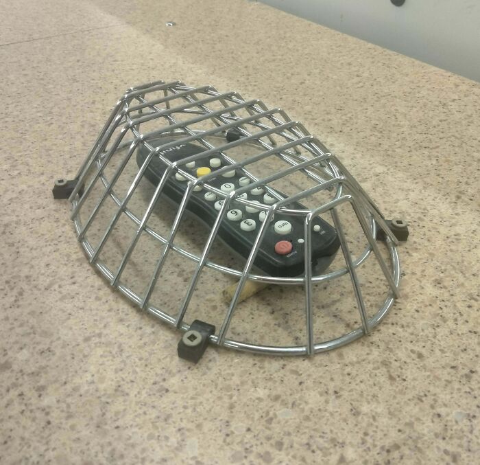 Protective metal cage to prevent remote control theft in public areas