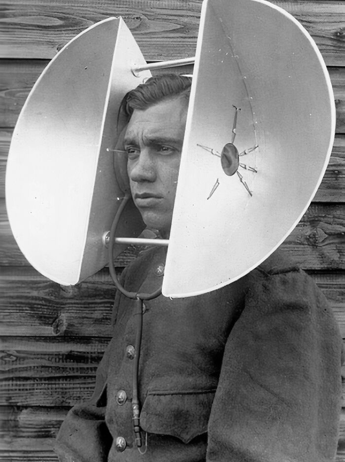 Vintage low-tech communication device with large ear trumpets worn by man