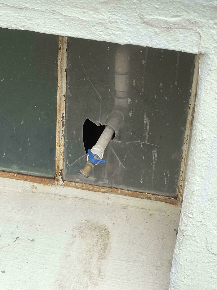A Funny 'You Had One Job' Fail: A water pipe extends through a broken window pane, illustrating a funny installation fail.