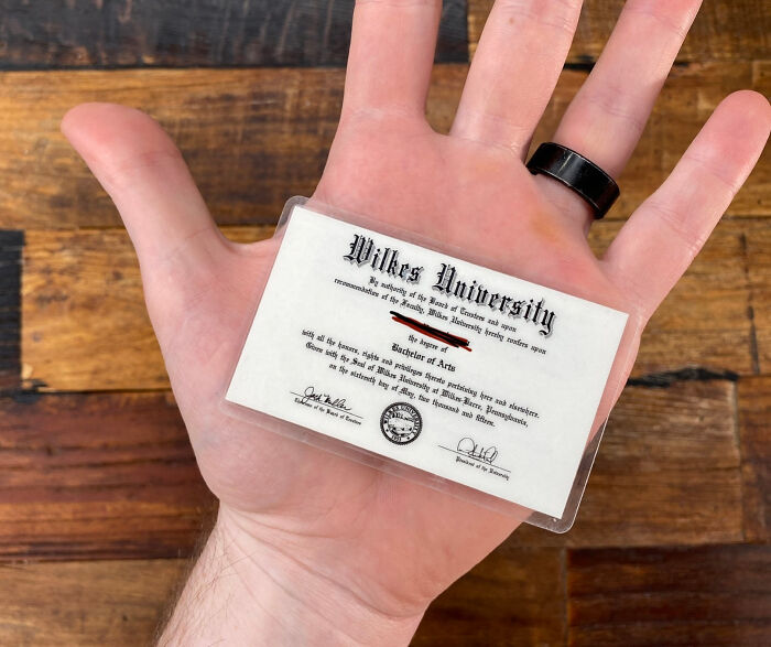 Hand holding a miniature Wilkes University diploma card