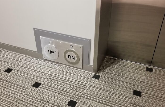 Elevator controls on the floor with up and down buttons for accessibility