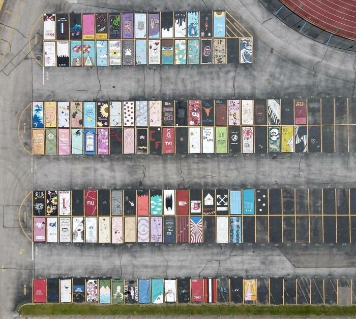 Aerial view of a campus parking lot with colorful painted parking spaces
