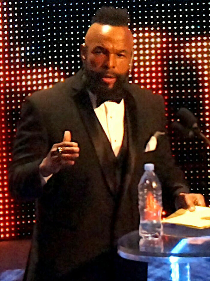 Mr. T speaking at event wearing tuxedo with iconic mohawk and beard