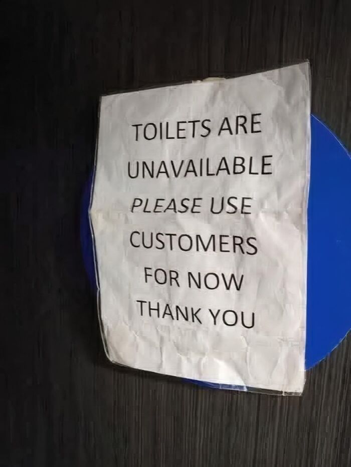 Paper sign incorrectly stating toilets are unavailable and to use customers