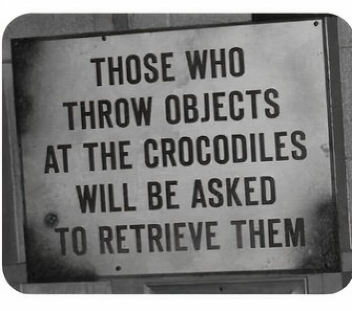 Absurd sign warns those who throw objects at crocodiles must retrieve them