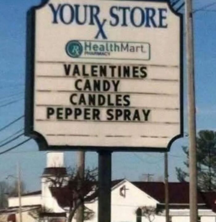 Absurd store sign listing valentines candy candles pepper spray
