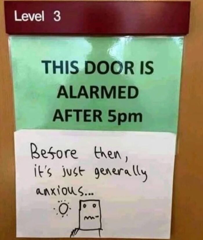 Absurd sign about alarmed door after 5pm with humorous handwritten note