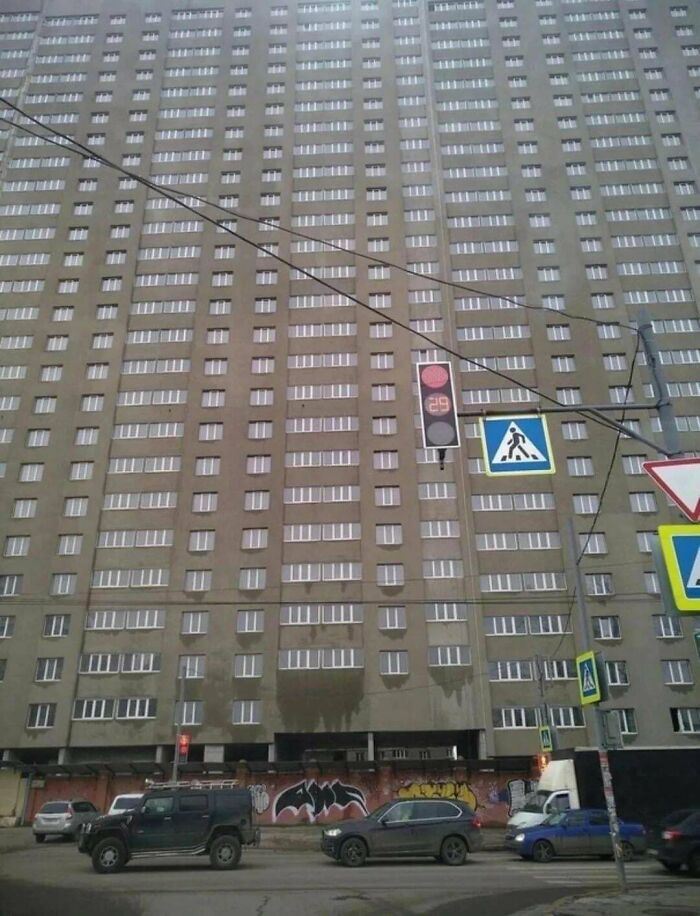 Urban hell apartment block with repetitive windows and traffic signs below