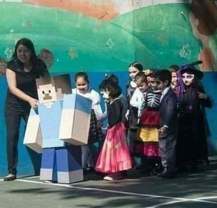 Adult helps kids in Minecraft costume at school event