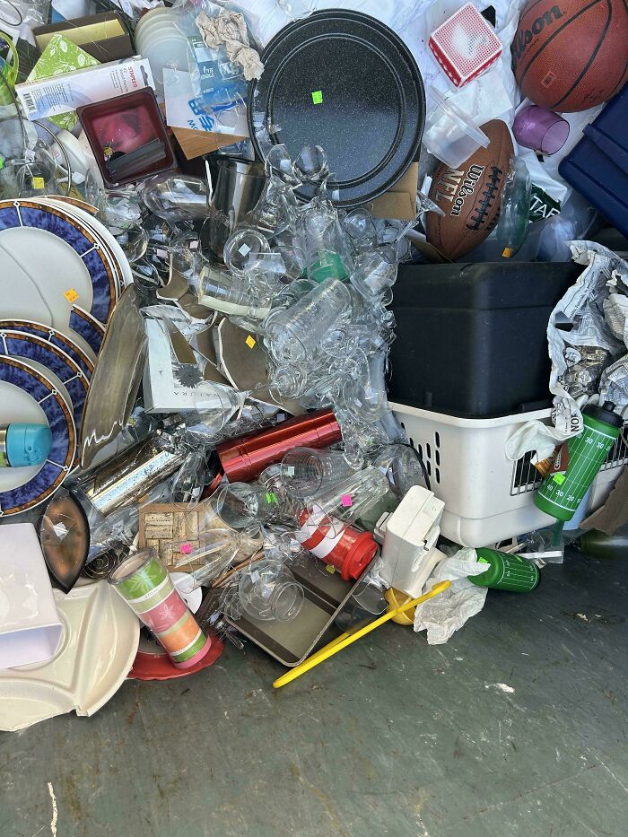 A dumpster overflowing with various discarded items, symbolizing excessive consumerism.