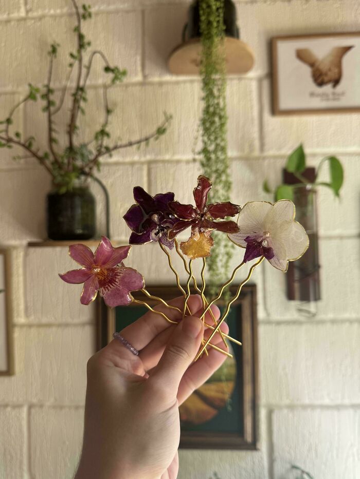 A hand holding multiple handmade flower hairpins, highlighting unique handmade projects.