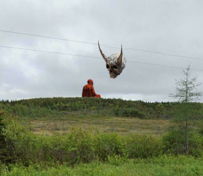Google Maps shenanigans showing a person on a hill and a giant skull-shaped balloon in sky