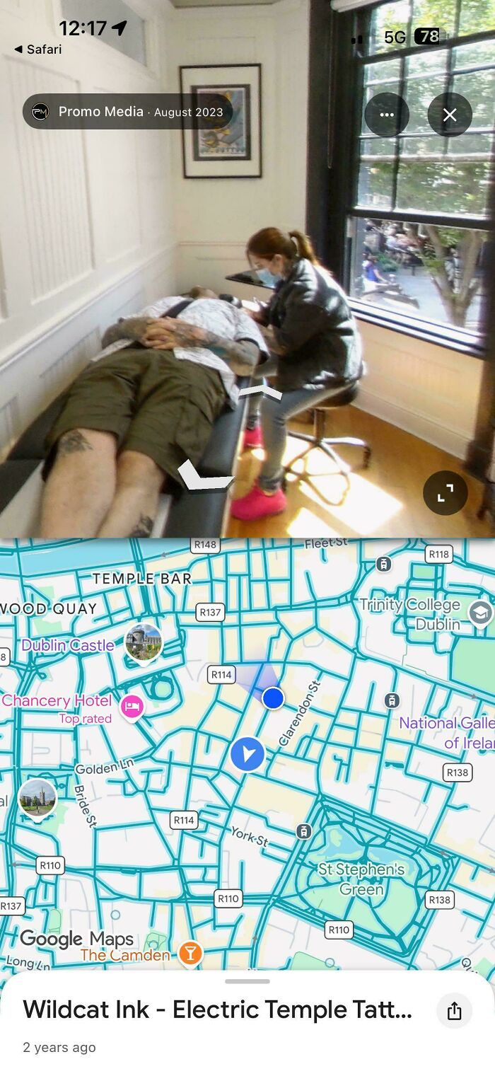 Tattoo artist working on client with Google Maps city map background