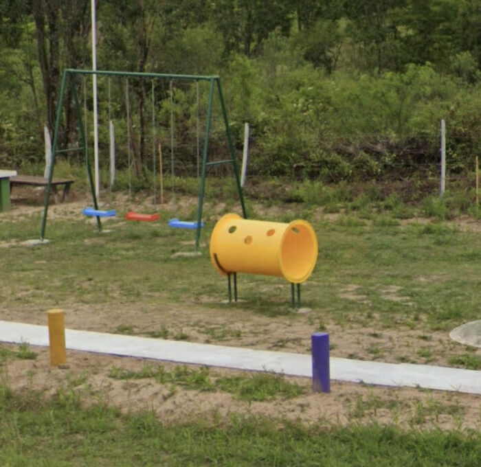 Playground with swings and yellow tunnel in Google Maps view