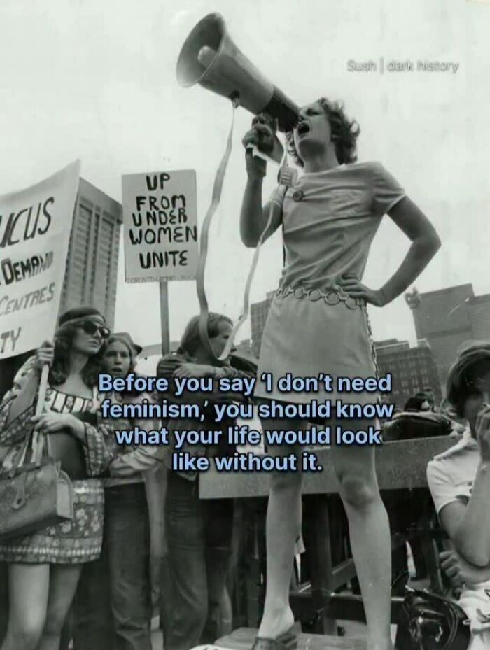 Black and white photo of feminist protester with megaphone and signs