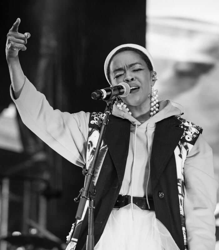 Lauryn Hill passionately singing into microphone during live performance