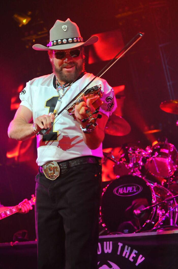 Hank Williams Jr. playing violin on stage during a live music performance