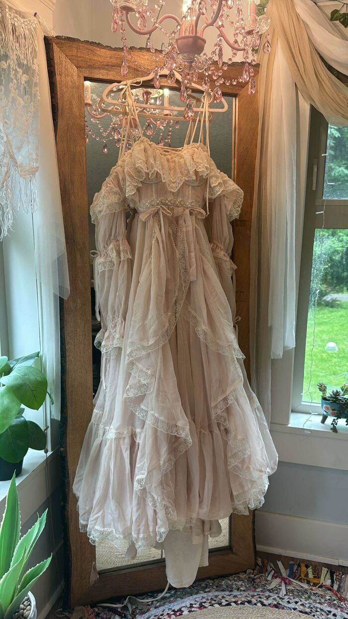 A flowing, layered, handmade dress in a pale pink color with lace details, reflecting talent and patience in its design.
