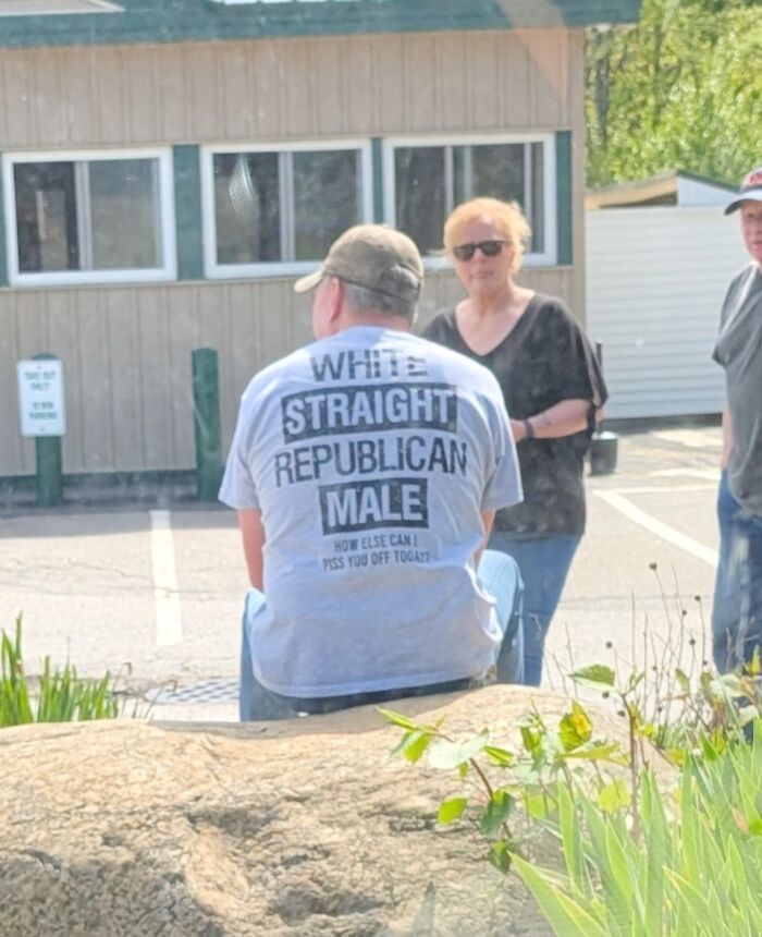 Man wearing t-shirt with political and demographic labels, reflecting confused market value theme