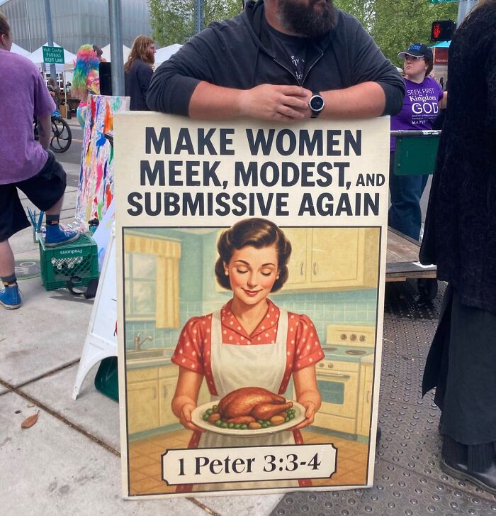 Protest sign with vintage image and text about making women meek modest and submissive