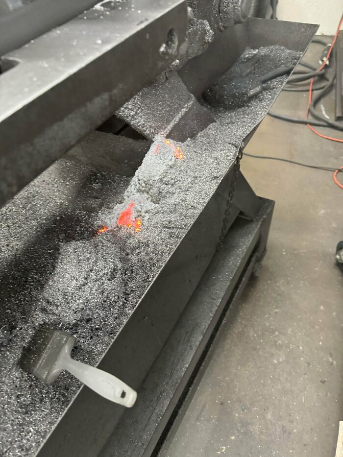 Molten metal and hot ash near brush on industrial machine risky survival situation