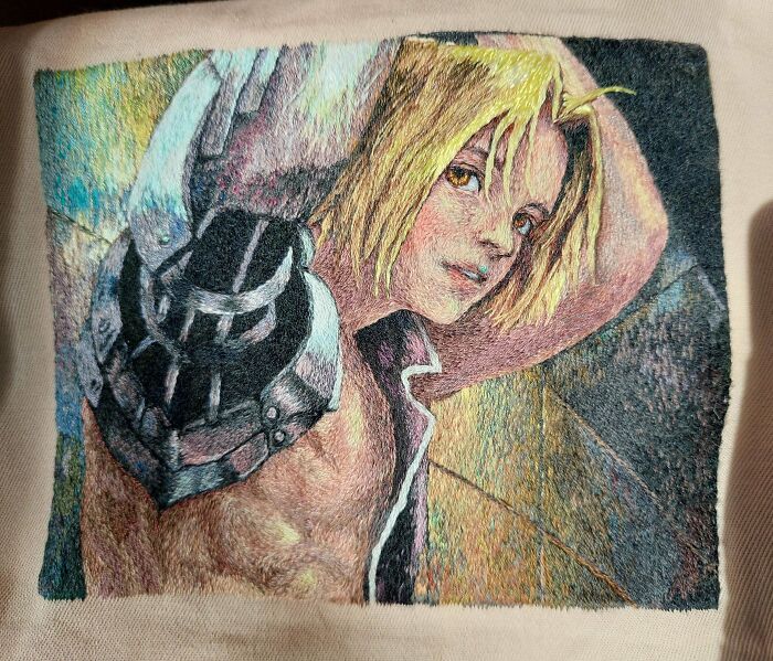 Close-up of a highly detailed hand-embroidered anime character portrait on fabric as an embroidery project
