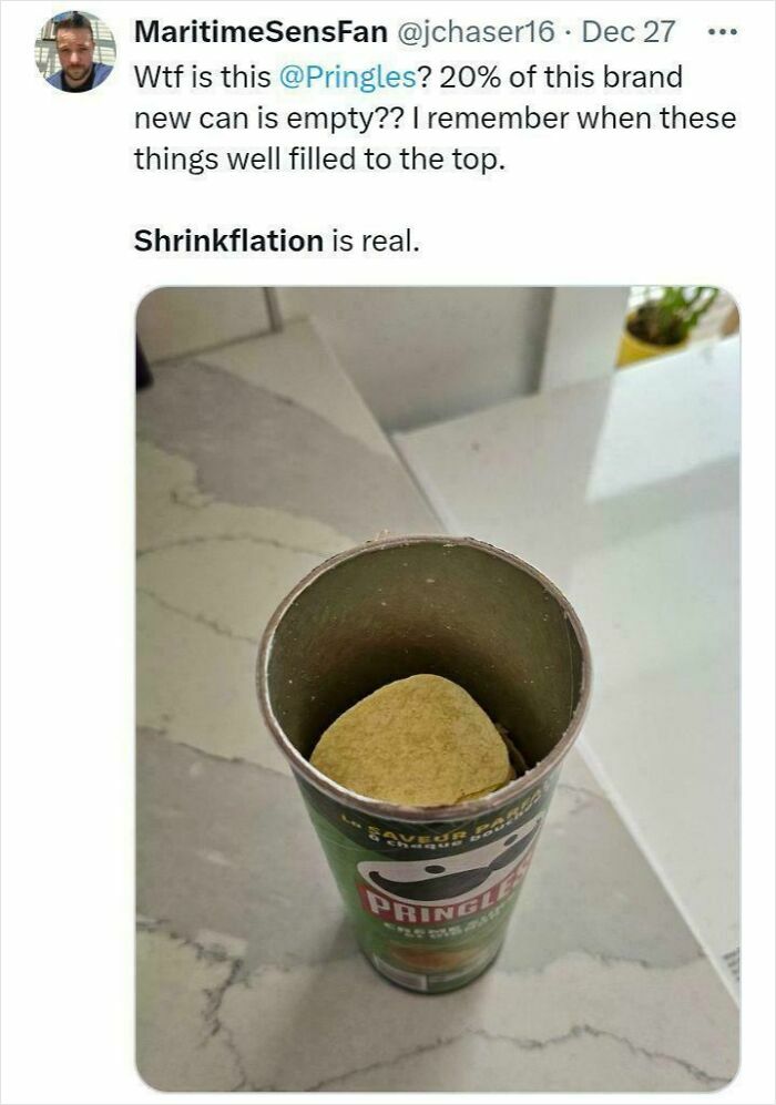 Pringles can with few chips inside highlighting shrinkflation complaint on potato chips