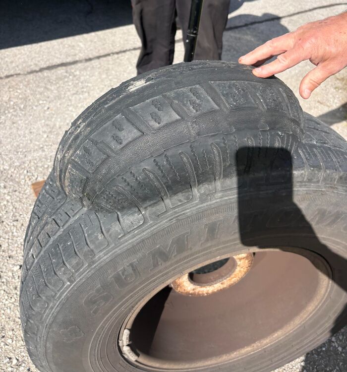 Worn tire with almost no tread in risky situation for survival on road