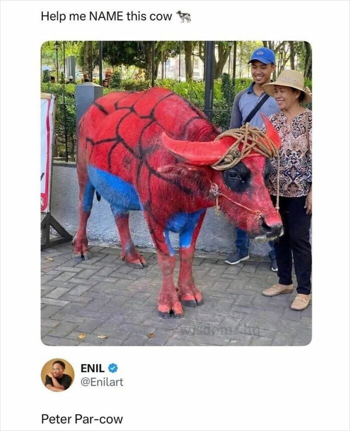 Red and blue painted cow with people smiling nearby