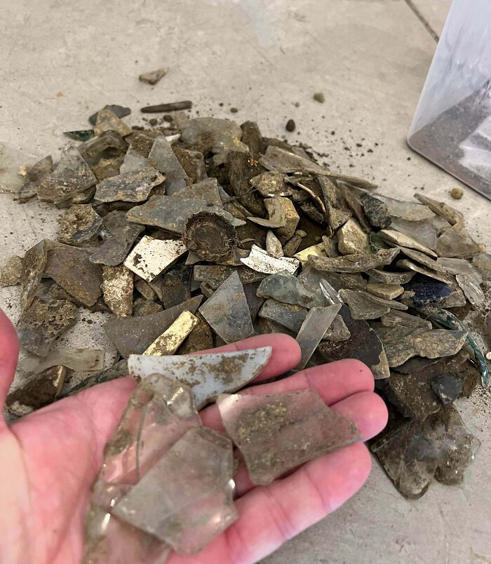 Pile of sharp broken glass pieces dirty on the floor showing risky survival situation