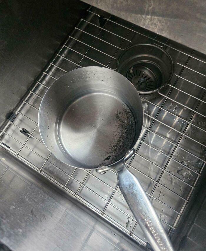 Saucepan with residue drying in a stainless steel kitchen sink