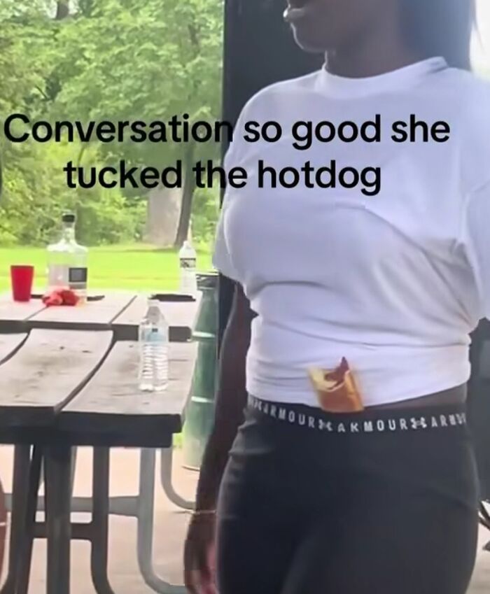 Woman tucking hotdog in waistband with funny humor caption