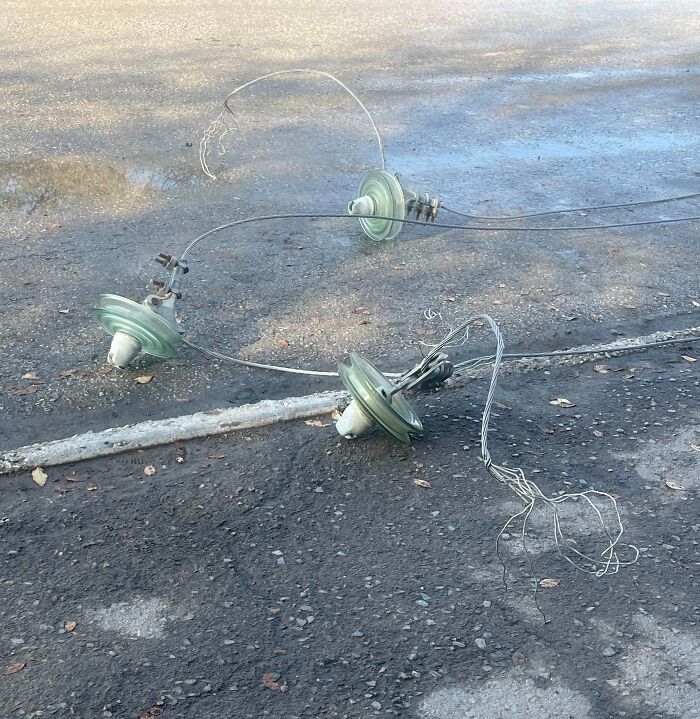 Damaged power lines with broken glass insulators on the ground