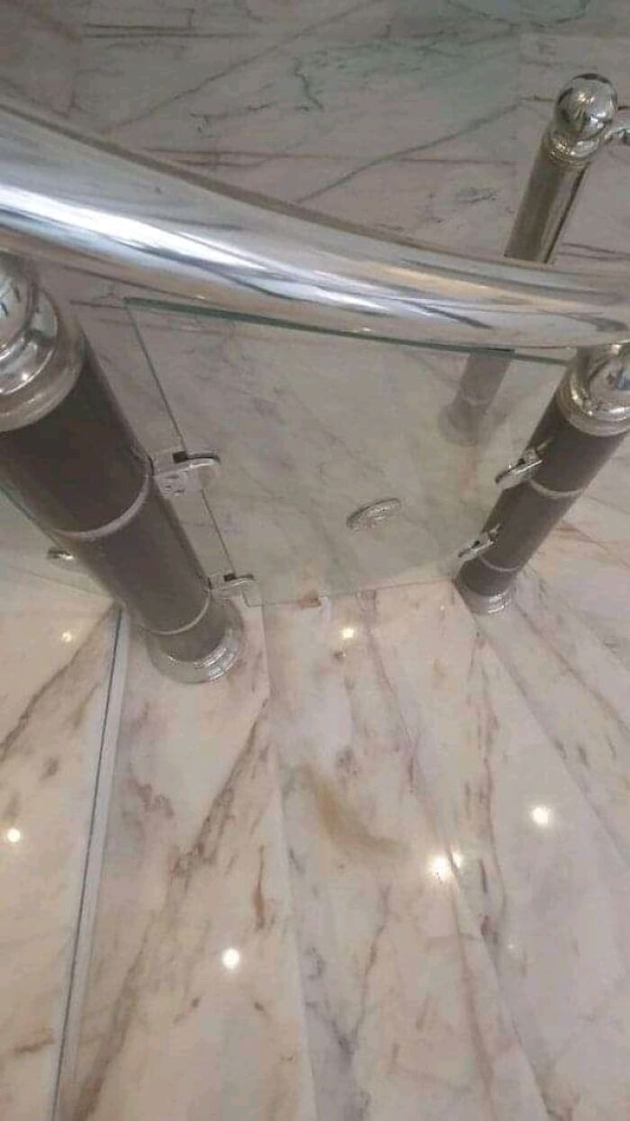 Transparent glass door blends into marble floor in elegant staircase