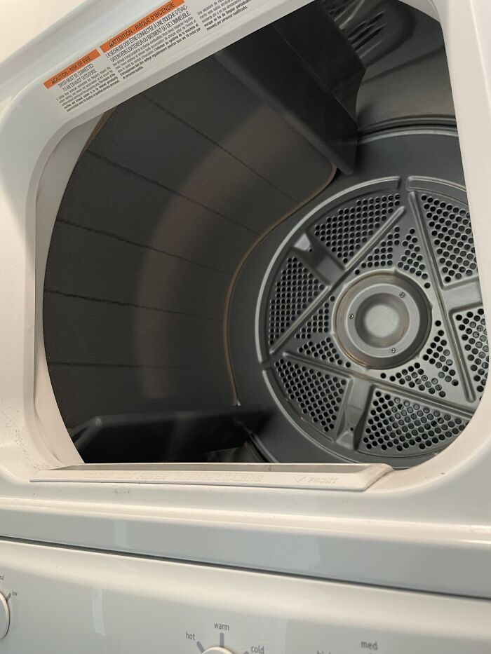 Empty dryer drum showing interior details in household appliance